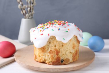 Lezzetli Paskalya pastası, boyanmış yumurtalar ve söğüt dalları beyaz ahşap masada, yakın plan.