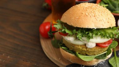 Tahta masada servis edilen vejetaryen köfteli ve sebzeli lezzetli burger. Metin için boşluk