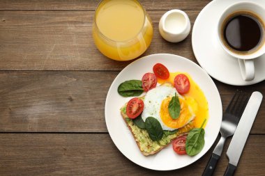 Tahta masada servis edilen avokado tostlu sağlıklı bir kahvaltı. Metin için boşluk