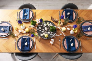 Paskalya kutlaması. Çiçekli şenlik masası ve kapalı alanda yumurtalar, düzlük.