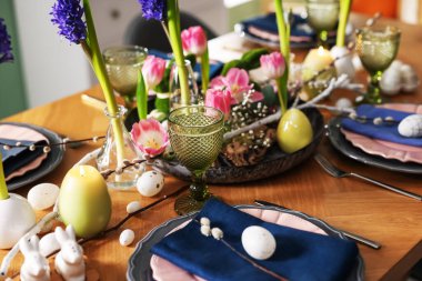 Paskalya kutlaması. Çiçekli şenlik masası ve kapalı mekanda yumurtalar, yakın plan.