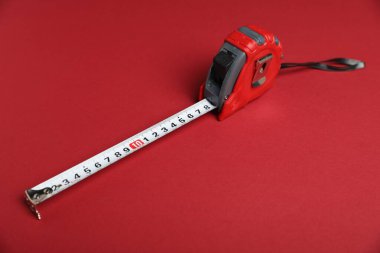 Kırmızı arkaplanda bir mezura, yakın plan