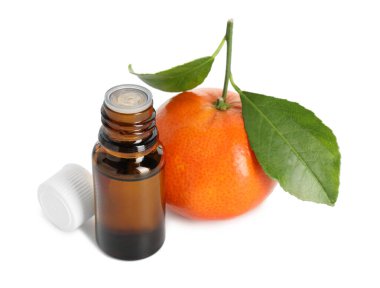 Beyaza izole edilmiş bir şişe mandalina yağı ve meyve.