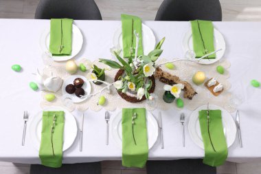 Paskalya kutlaması. Zarif bulaşık takımları ve çiçekli şenlik masası, üst görünüm