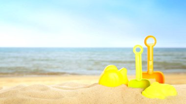 Deniz kenarındaki kumda parlak plastik plaj oyuncakları, pankart tasarımı. Yaz zamanı.