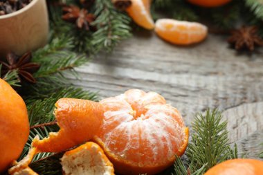 Olgun mandalinalar, baharatlar ve köknar ağacı dalları ahşap masada, yakın plan. Metin için boşluk