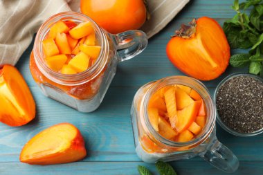 Kavanozda hurma çekirdeği pudingi ve açık mavi ahşap masada nane şekeri.