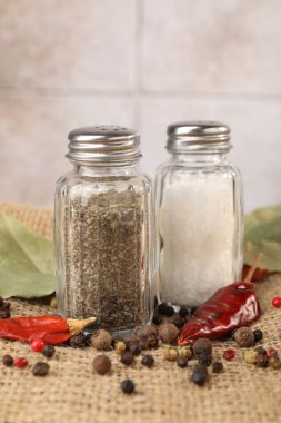 Çuval bezinde baharat olan tuzluk ve biberlikler bulanık arka planda, yakın plan