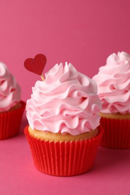 Sevgililer Günün kutlu olsun. Pembe arka planda krem şantili lezzetli kekler, yakın plan.