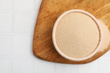 Beyaz fayanslı masada, kasede kuru maya, üst manzara. Metin için boşluk