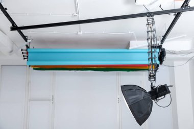 Fotoğraf stüdyosunun tavanından sarkan profesyonel ışıklandırma ekipmanları.