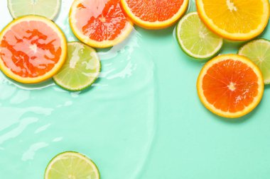 Turkuaz arka planda sudaki narenciye dilimleri, düzlük.