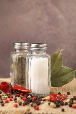 Çuval bezinde baharat olan tuzluk ve biberlikler bulanık arka planda, yakın plan