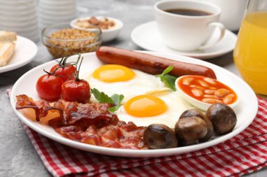 Geleneksel İngiliz kahvaltısı desenli gri masada servis edilir, yakın plan.