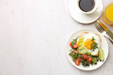 Avokado tostlu sağlıklı bir kahvaltı. Işık masasında servis ediliyor. Metin için boşluk