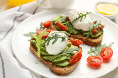 Avokado tostları ve haşlanmış yumurtalarla nefis bir kahvaltı, yakın plan.