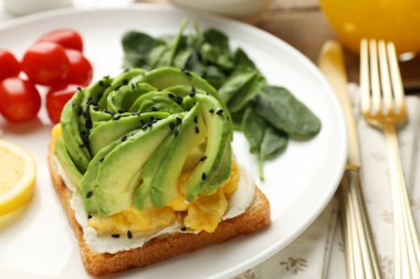 Avokado tostlu lezzetli bir kahvaltı, masada servis edilir, yakın plan.