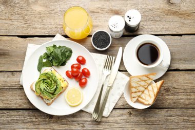 Tahta masada servis edilen avokado tostuyla nefis bir kahvaltı.