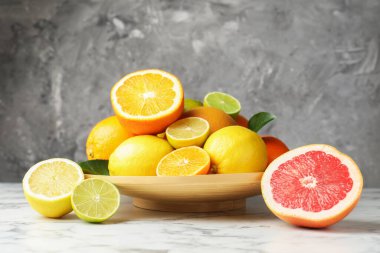 Beyaz mermer masada farklı olgun narenciye meyveleri