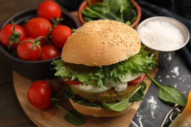 Tahta masada servis edilen vejetaryen köfteli ve sebzeli lezzetli burger.