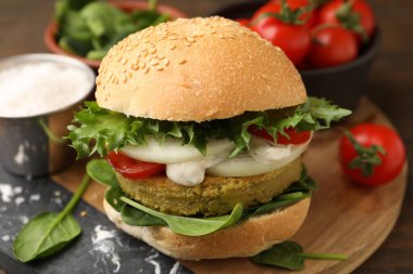 Tahta masada servis edilen vejetaryen köfteli ve sebzeli lezzetli burger.