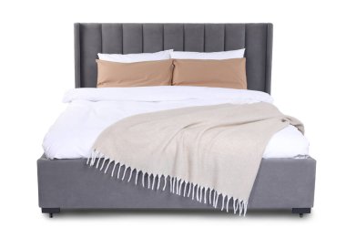 Büyük yatak bej battaniyeli ve beyaz yastıklı.