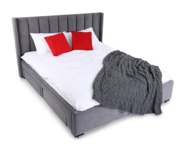 Gri battaniyeli büyük yatak ve beyaz yastıklı kırmızı yastıklar.