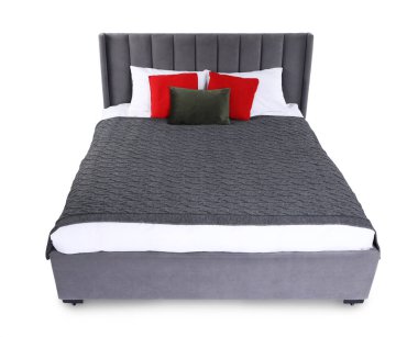 Gri battaniyeli büyük yatak ve beyaz yastıklı kırmızı yastıklar.