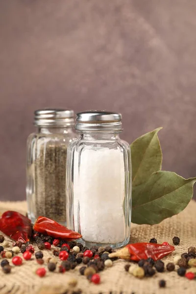 Çuval bezinde baharat olan tuzluk ve biberlikler bulanık arka planda, yakın plan