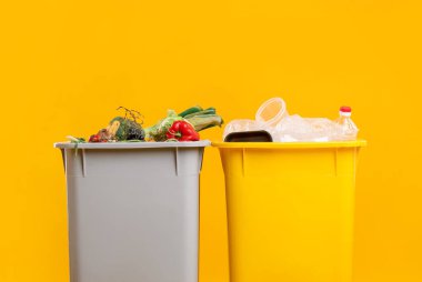 Çöp tenekeleri turuncu arka planda, yakın plan. Atık sıralama