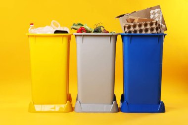 Çöp tenekeleri turuncu arka planda. Atık sıralama