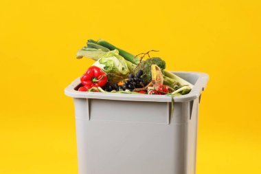 Çöp tenekesi turuncu arka planda, mesaj için yer var. Atık sıralama