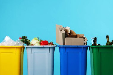 Çöpler açık mavi arka planda çöp kutularında, yakın plan. Atık sıralama