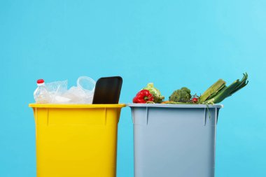 Çöpler açık mavi arka planda çöp kutularında, yakın plan. Atık sıralama