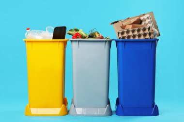 Açık mavi arka planda çöp kutuları. Atık sıralama