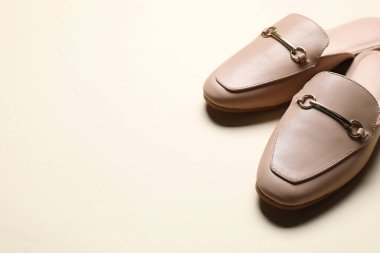 Bej arka planda bir çift şık katır ayakkabısı, yakın plan. Metin için boşluk
