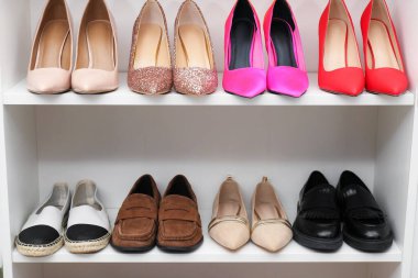 Ayakkabı deposu. Farklı ayakkabı giyimli raf ünitesi, yakın plan.