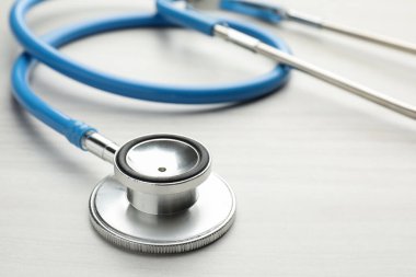 Mavi steteskop açık ahşap masada, yakın plan.