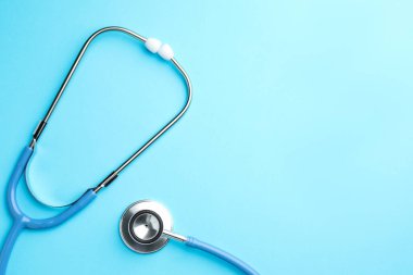Açık mavi arka planda steteskop, üst manzara. Metin için boşluk