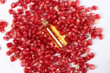 Beyaz zemin üzerinde gerekli yağ ve nar tohumları, üst görünüm