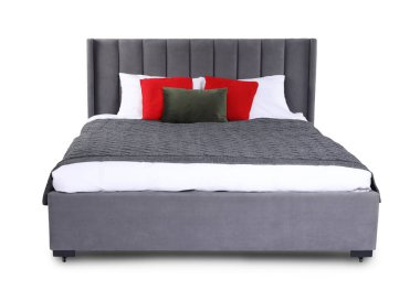 Gri battaniyeli büyük yatak ve beyaz yastıklı kırmızı yastıklar.