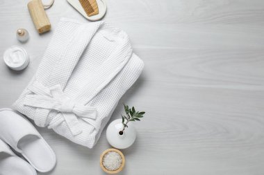 Bornozlu düz kompozisyon ve beyaz ahşap arka planda spa gereksinimleri. Metin için boşluk