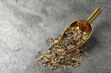 Gri masada kurutulmuş yeşil çay yaprakları ve metal spatula, yakın plan. Metin için boşluk