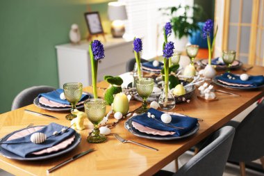 Paskalya kutlaması. Çiçeklerle süslü masa ve kapalı alanda yumurtalar.