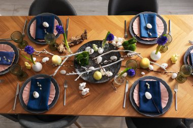 Paskalya kutlaması. Çiçekli şenlik masası ve kapalı alanda yumurtalar, düzlük.