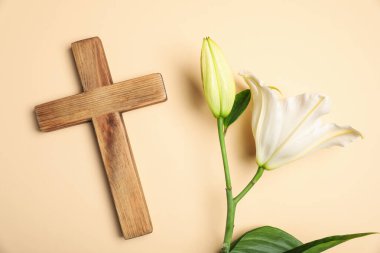 Paskalya. Ahşap haç ve bej arka planda güzel zambak çiçekleri, düz uzanmış