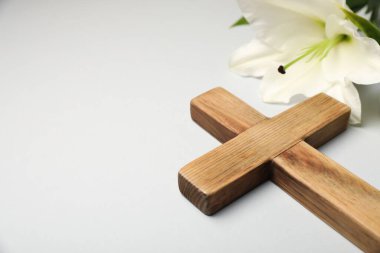 Paskalya. Ahşap haç ve gri arkaplanda güzel zambak çiçeği, metin için yere yakın çekim