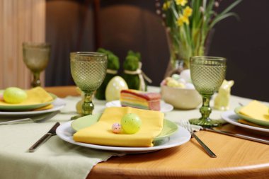 Paskalya kutlaması. Zarif bulaşık takımları ve boyalı yumurtalarla şenlik masası, yakın plan.