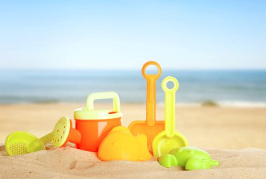 Deniz kenarındaki kumda parlak plastik plaj oyuncakları. Yaz zamanı.