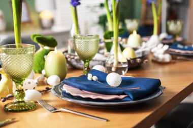 Paskalya kutlaması. Çiçekli şenlik masası ve kapalı mekanda yumurtalar, yakın plan.